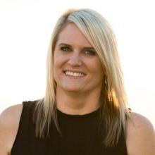 head shot of Tara McLaughlin, a blonde-haired woman wearing a black sleeveless shirt